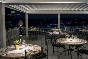 A rooftop dining area with tables, chairs, and potted plants. - PALAZZO RIAMA AGRIRESORT (Naples)