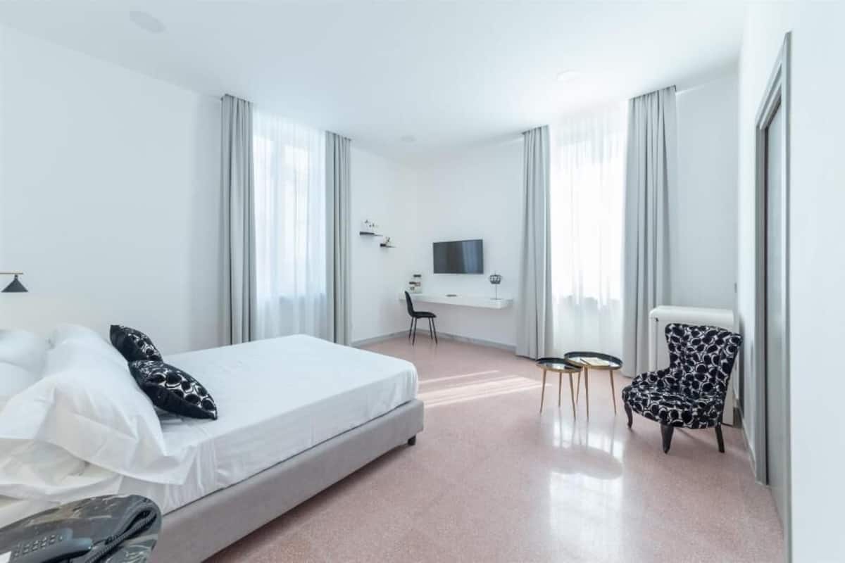 Een hotelkamer met een bed, een bureau, een stoel en een televisie.