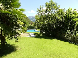 Ein Garten mit Schwimmbad, üppigem Grün und einem Holzzaun.