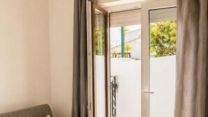 Un saló modern amb un sofà, una porta corredissa de vidre que dona a zona exterior i una làmpada al sostre.