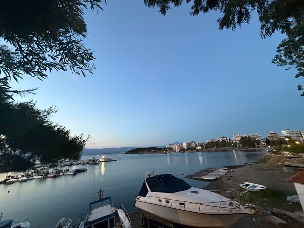 Un puerto deportivo con barcos amarrados, una masa de agua tranquila y edificios al fondo.