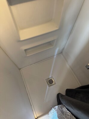 A corner of a room with a white wall, a vent, and a drain. - Adorable private room at side of house  in Norwalk perfect for your next getaway (Norwalk)
