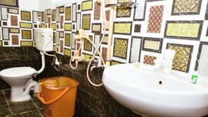 A bathroom with a toilet, sink, and shower.