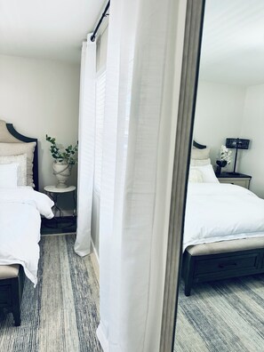 Ein Hotelzimmer mit einem Bett, einem Nachttisch, einer Lampe und einem Spiegel.