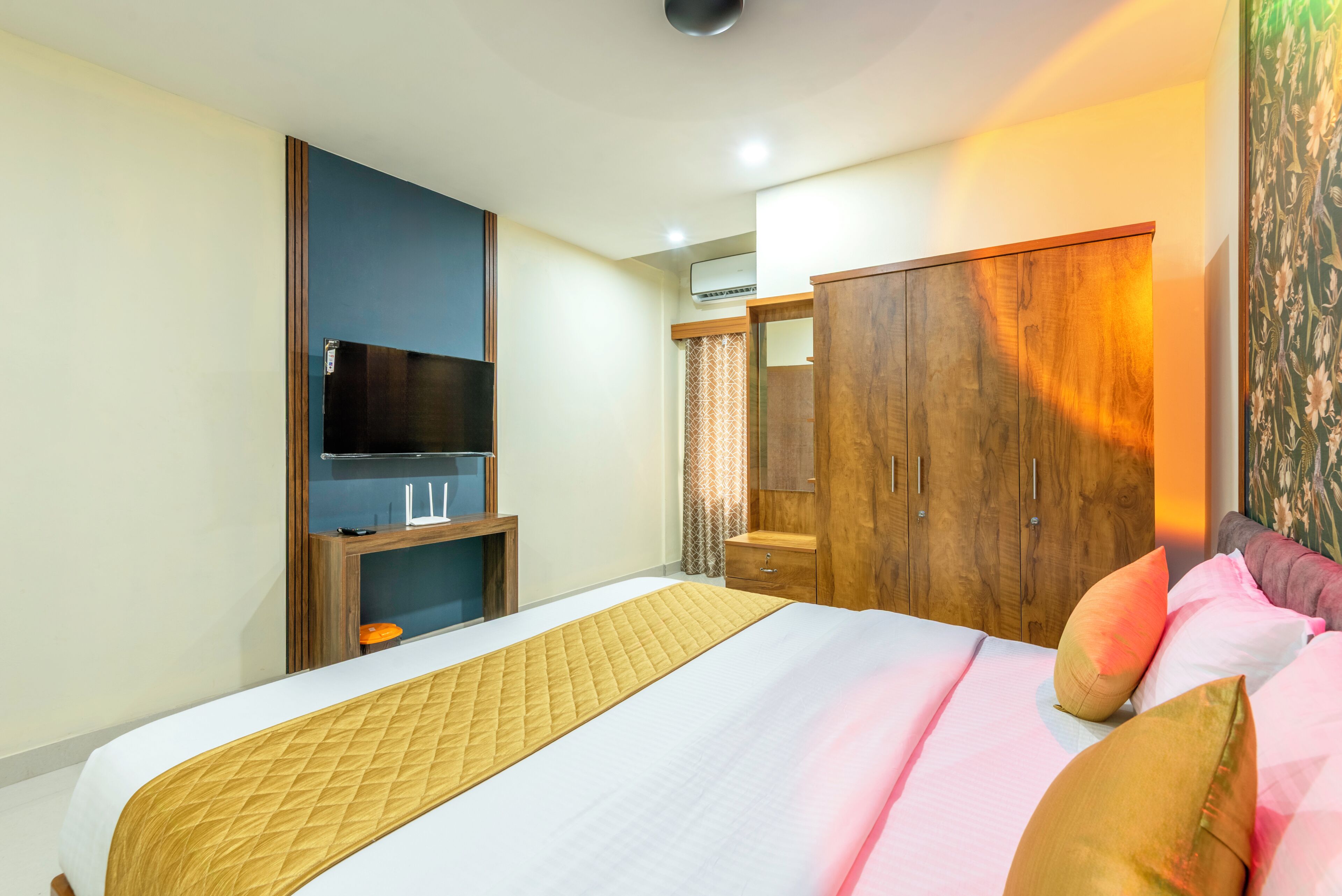 A hotel room with a bed, wardrobe, TV, and a small table.
