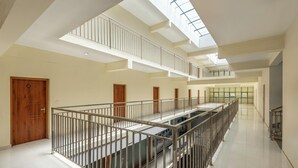 A multi-level interior with a central staircase, railings, and a skylight.