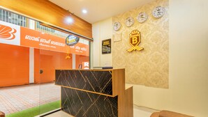 A reception desk with a patterned backdrop, a clock, and a sign with a logo.