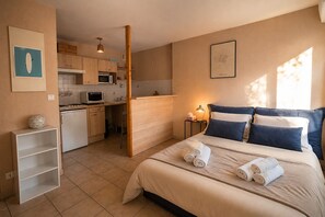 A bedroom with a bed, pillows, and a nightstand with a lamp. - Pleasant studio in La Rochelle (La Rochelle)