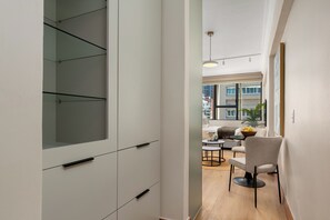 Ein modernes Interieur mit einer Glasschrank, einem Essbereich mit Tisch und Stühlen sowie Blick ins Freie.