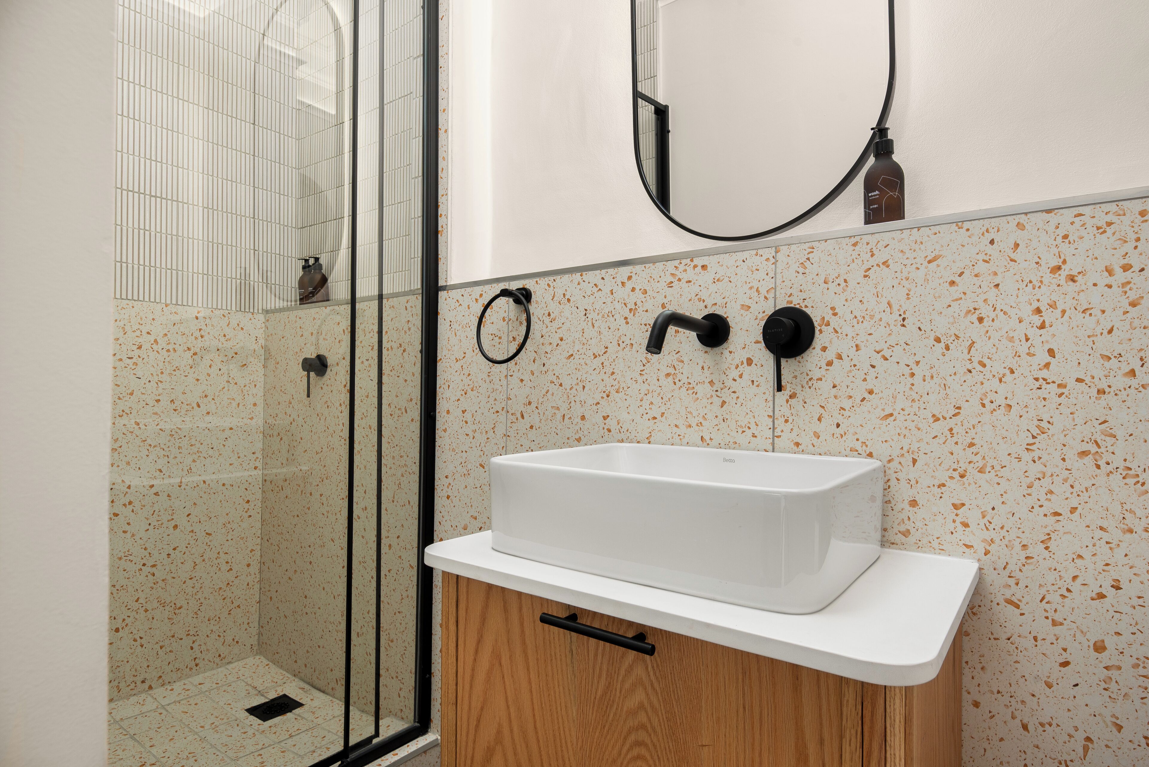 Ein Badezimmer mit Dusche, Waschbecken und Spiegel.
