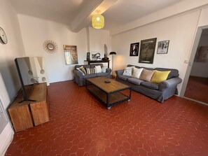 Ein Wohnzimmer mit einer Sofagarnitur, einem Couchtisch und einer Lampe.