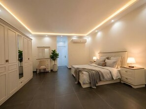 Un dormitorio con cama, mesitas de noche, escritorio y armario.
