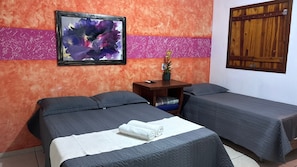 A hotel room with two beds, a nightstand, a framed abstract painting, and a wooden door. - POUSADA MOAÇARA (Nobres)