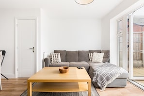 A living room with a sofa, a coffee table, and a door. - 2 Bed Modern Terrace, Leamington Spa - Pass the Keys (Leamington Spa)