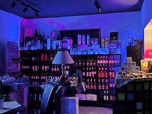 A bar area with shelves of bottles, a lamp, and various bar accessories.