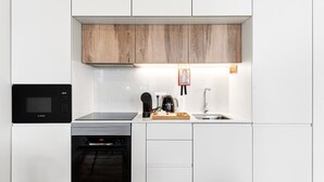 Cocina compacta con microondas Bosch, cafetera, tostadora y pileta.