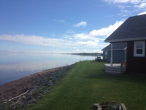 A lakeside property with a house, a lawn, and a golf cart.