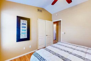 A bedroom with a bed, a door, and a wall-mounted artwork. - Spacious Home in a Central Location w/ Private Pool & Fire Pit (Gilbert)