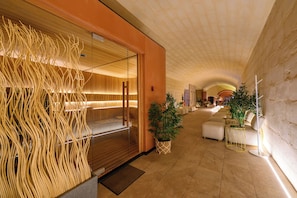 Eine Hotelhalle mit modernem Design, mit einer Holzwand, einer Glastrennwand und einer Sitzecke mit Pflanze.