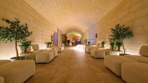 A spacious lobby with a high arched ceiling, plush seating, and potted plants. - 24th Floor Sea Front view Apart Hotel Mercury Tower 3 Pools-Cave Spa-Gym-Rooftop (St. Julian's)
