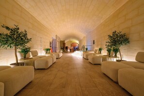 Eine geräumige Lobby mit hoher, gewölbter Decke, bequemen Sitzgelegenheiten und Topfpflanzen.
