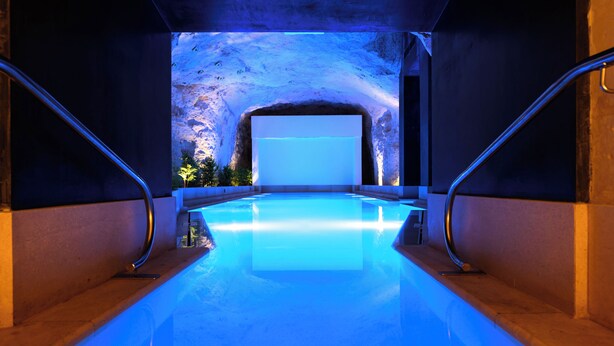A swimming pool with a view of a cave-like structure in the background. - 24th Floor Sea Front view Apart Hotel Mercury Tower 3 Pools-Cave Spa-Gym-Rooftop (St. Julian's)