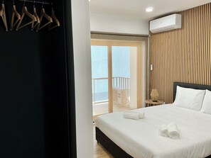 Ein Hotelzimmer mit Bett, einer Holzwand, einer Klimaanlage und Blick durch eine Glastür.