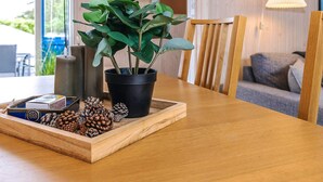 Una mesa de madera con una planta en maceta, piñas y una bandeja decorativa.