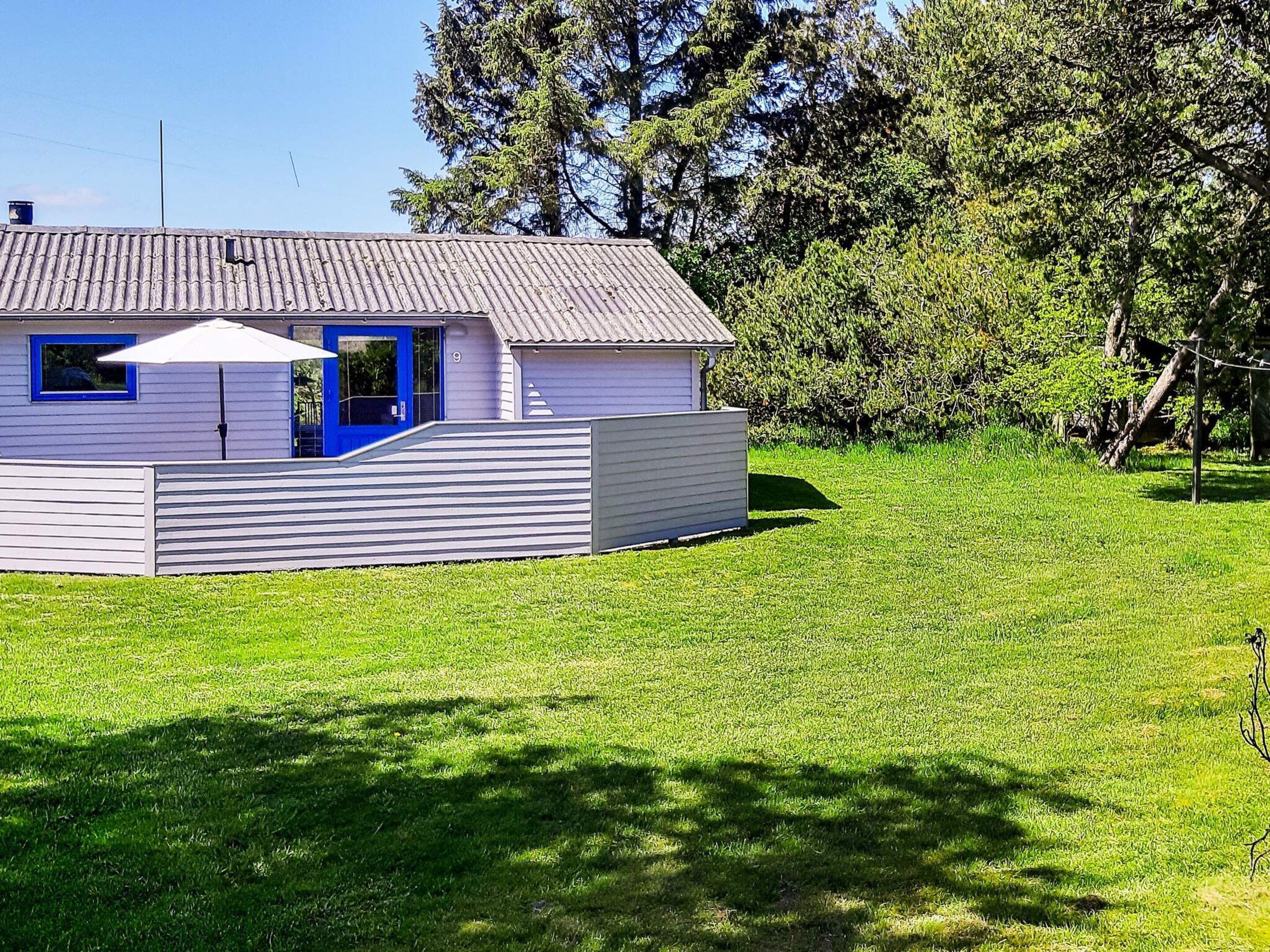 Um edifício térreo com uma porta azul e uma pequena construção anexa.