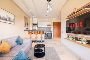 Ein modernes Wohnzimmer mit einer Couch, einem Couchtisch und einer Küche im Hintergrund.