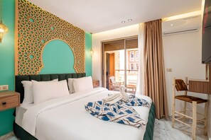 Ein Hotelzimmer mit Bett, Wanddeko, Fenster und Sessel.