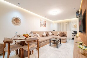 Ein modernes Wohnzimmer mit Sofa, Couchtisch und Essbereich.