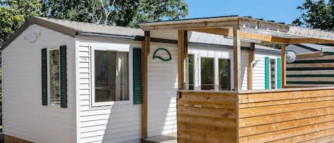 Ein kleines, eingeschossiges Holzhaus mit einer Veranda und einer kurzen Treppe zum Eingang.