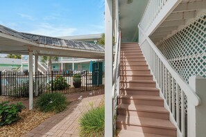 A covered outdoor area with a staircase leading to a building.