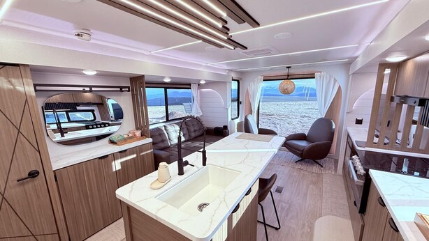 Un interno moderno con cucina, zona pranzo e posti a sedere vicino a una grande finestra con vista sul mare.
