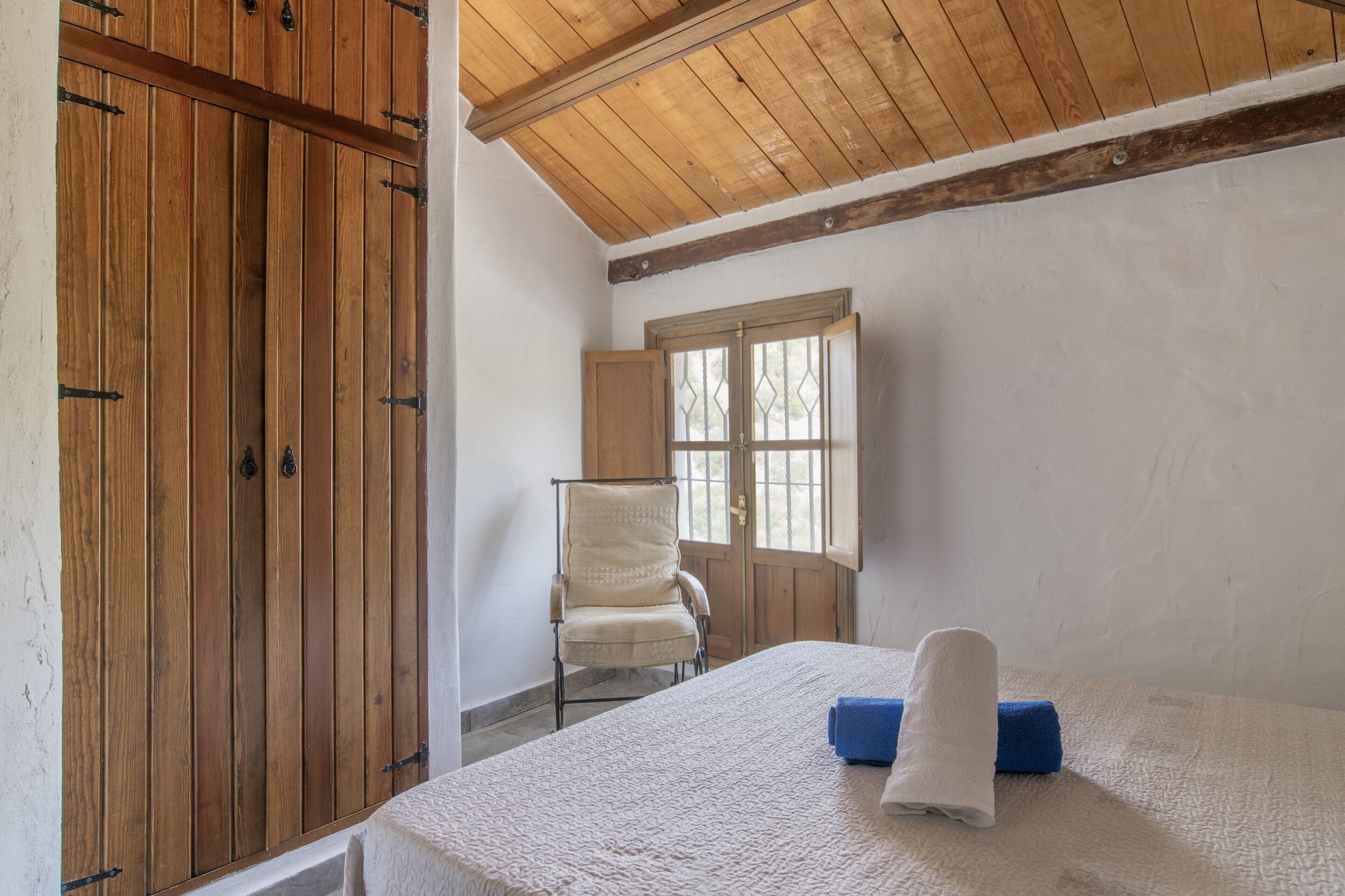 Une pièce comprenant un lit, une chaise et une armoire.