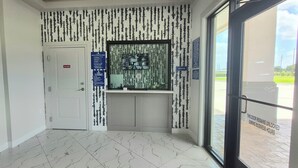 A hallway with a door marked 'No Entry,' a trash bin, a sign with instructions, and a window with a view of the outside. - Platinum Inn Copperfield (Houston)