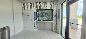 A hallway with a door marked 'No Entry,' a trash bin, a sign with instructions, and a window with a view of the outside. - Platinum Inn Copperfield (Houston)