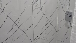 A shower with a white marble wall and a white bathtub. - Platinum Inn Copperfield (Houston)