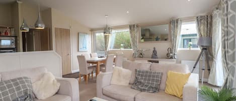 A living room with a sofa, a coffee table, and a dining area with chairs and a table.