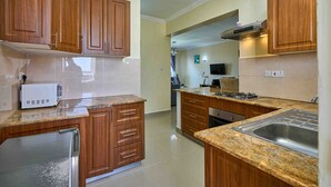 Una cocina con armarios de madera, un microondas y un lavamanos de acero inoxidable.