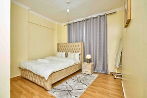Ein Schlafzimmer mit einem großen Bett, einem Nachttisch und einer Stehlampe.