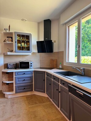 Eine moderne Küche mit integriertem Mikrowellenherd, einer Spüle und einem Fenster mit Blick auf Grünflächen.