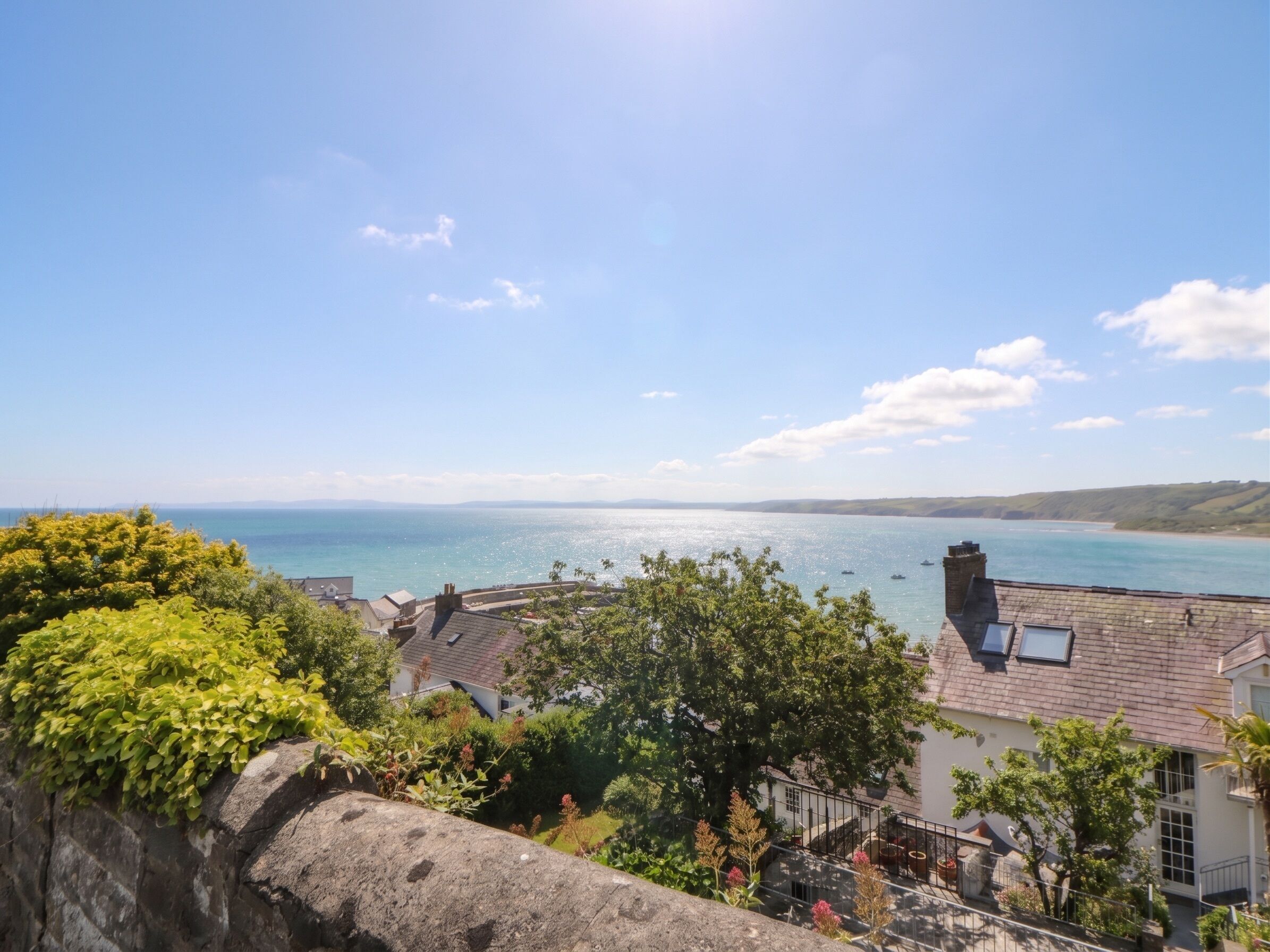 A coastal town with stone buildings, a clear sky, and a view of the sea.