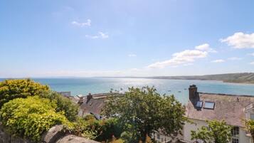 A coastal town with stone buildings, a clear sky, and a view of the sea.