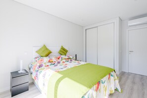 Ein Schlafzimmer mit Bett, Nachttisch, Kleiderschrank und einer Tür.
