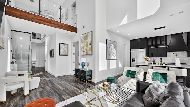 A modern living room with a sofa, coffee table, and a dining area with a kitchen in the background. - Welcome to The Hollywood House, a glamorous 5 bedroom, 4 bathroom escape in the aptly named Dallas Hollywood neighborhood. (Dallas)
