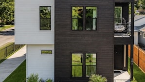 A modern two-story house with a balcony, a small garden, and a clear sky. - Welcome to The Hollywood House, a glamorous 5 bedroom, 4 bathroom escape in the aptly named Dallas Hollywood neighborhood. (Dallas)