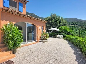 Eine Villa mit Terrasse, Essbereich und Blick auf die umliegende Landschaft.