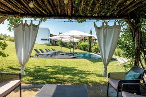 A covered outdoor seating area with a pool, lounge chairs, and umbrellas. - Pool house 5 mins from town among vineyards (Novello)